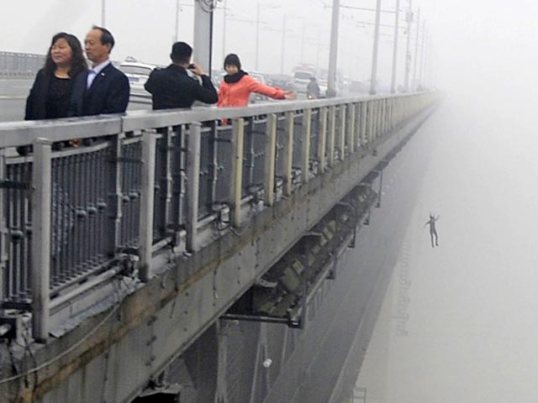 A combination photograph shows a person jumping off the Wuhan Yangtze River Bridge in Hubei province
